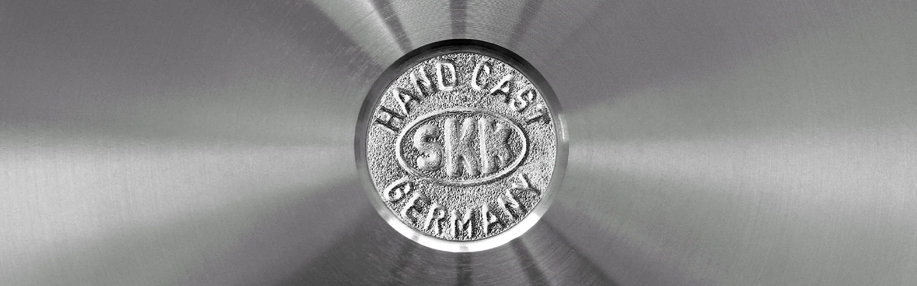 Das auf der Serviceseite als Header platzierte Foto zeigt eine Nahaufnahme einer Edelstahlpfanne von SKK Guss Germany.